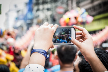 Taking photos and videos using the phone during the Chinese New Year celebration at Manila Chinatown