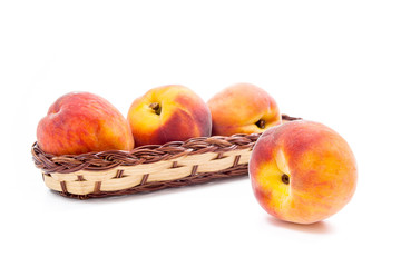 Single ripe peach fruit and several in basket isolated on white background.