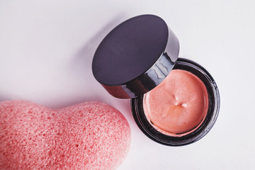 Cosmetic set of pink clay face mask and light pink heart shaped konjak sponge
