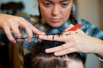 Fototapeta premium Master cuts hair and beard of men in the barbershop