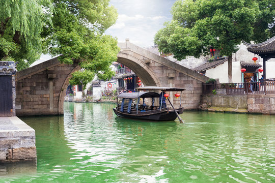 Brücke und vorbeifahrende Gondel in der antiken  Wasserstadt Tongli bei Shanghai in China