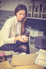 Young business woman working on laptop at cafe.