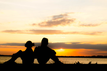 The silhouette of a woman is talking lazily in the evening when the sun is falling.