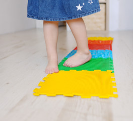 Baby foot massage mat. Exercises for legs on orthopedic massage carpet.