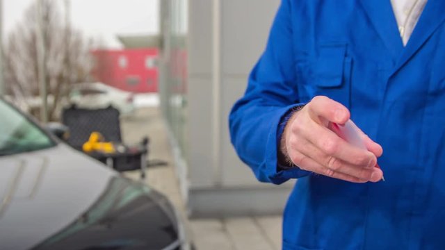 A client is signing the work order and he is giving the pen back to the automotive service consultant.