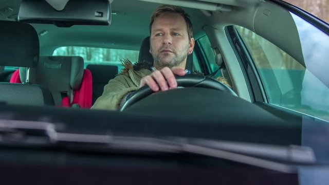 A man is driving and he is focused on the road.