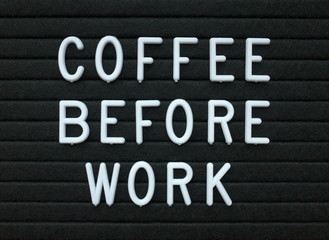 The words Coffee Before Work in white plastic letters on a black letter board as a reminder of your daily routine and preparation for the day