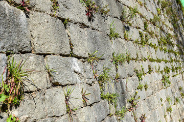 Old stone castle wall made of stone brick slabs.