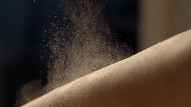 close up shot of the woman's foot, the beautician applies a white powder on the body to degrease the skin, then there will be a shugaring process