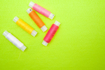 Multicolored thread coils red pink yellow white on green background