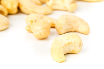 Close up of raw, organic, whole cashew nut kernels over white background