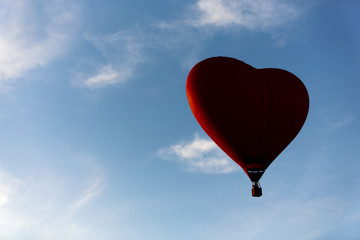 Fototapeta premium Red hot air balloon in the shape of a heart fly in sky. Love, honeymoon and romantic travel concept