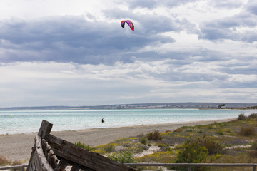 Professional Kitesurfer / Kitesurfing in the Mediterranean sea practicing with his Kiteboarding in the blue sea of the Mediterranean in the middle of winter