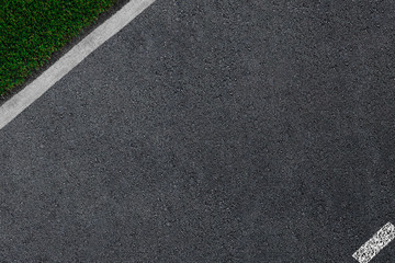 the asphalt which is smoothly passing to a white border and a green grass