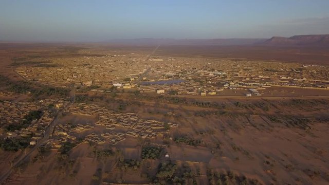 Smooth straight aerial shot over north african city in beautiful sunset light, Atar, Sahara, Adrar, Mauritania