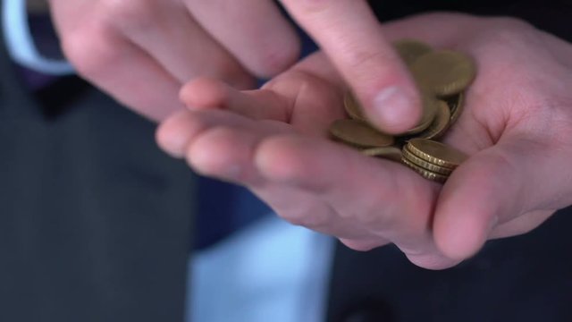 Man in suit counting cents, concept of low initial capital for personal startup