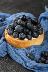 Delicious blueberry tart on black background