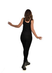 full length portrait of brunette girl wearing black singlet, jeans jeans and boots. standing pose, with back view. isolated on white studio background.