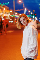 portrait of a beautiful young blonde girl in a night city