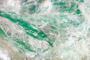 Macro shooting of natural gemstone. The raw mineral is talc .