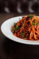 spaghetti Bolognese with minced beef and tomato sauce garnished with parmesan cheese and basil , Italian food