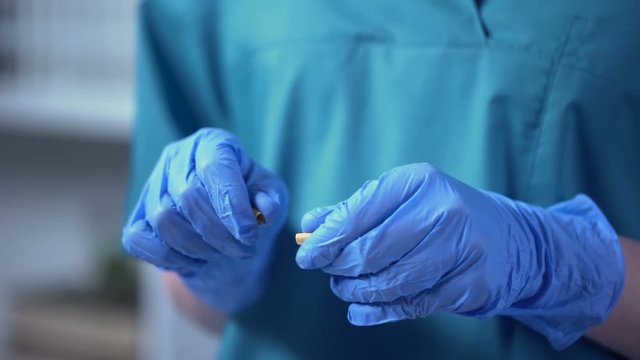 Lab assistant pouring simple painted powder from pill, falsified medicines