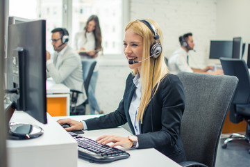 Attractive businesswoman with headset working in call center
