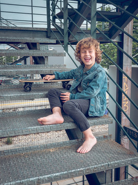 Child in bare feet sitting on stairs