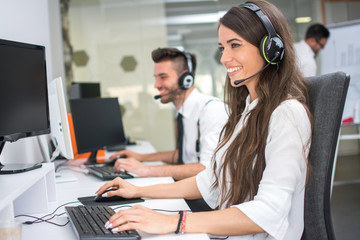 Helpline operators with headphones working in call centre