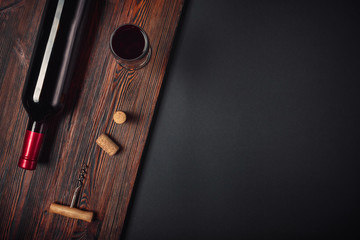Bottle of wine corkscrew and wineglass on rusty background