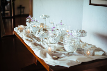 table with glass jars containing traditional Italian almond sweets, sweets for weddings
