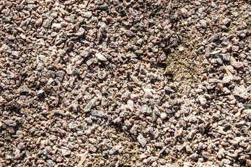 The texture of the lawn covering of small stone and granite chips. Background of rough coarse close-up.
