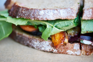 Gourmet mixed vegetable sandwich resting on a wooden table