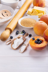 Ingredients for baking fruit pie on white table.