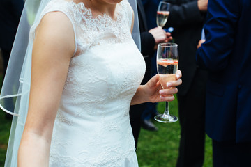 bride during the wedding party holding a glass of sparkling white wine