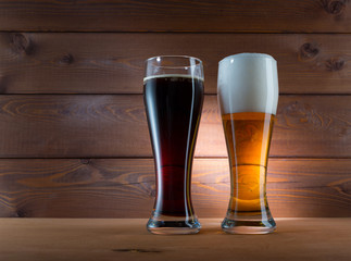 Two glasses of different colored beer on wooden background