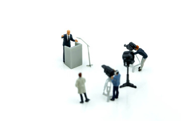 Fototapeta na wymiar Miniature people : journalists , cameraman ,Videographer at work shooting of the campaign