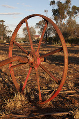 Quorn South Australia,  view of field through wheel of obsolete farming equipment left to rust in the afternoon light