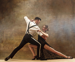 Flexible young modern dance couple posing in studio. - obrazy, fototapety, plakaty