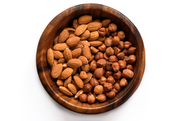 Almond and hazelnuts in wooden bowl, isolated on white- Nuts series