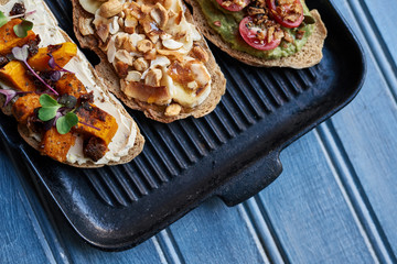 Skillet cooked open faced sandwiches on a rustic blue table