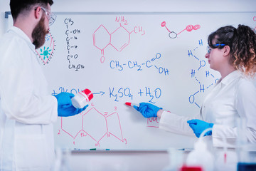 Young Scientist Standing In Front Of Board In Laboratory