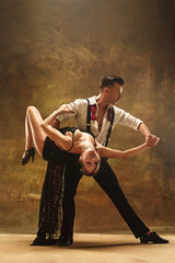 Flexible young modern dance couple posing in studio.
