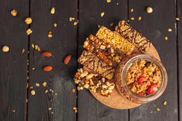 Healthy bars with nuts, seeds and dried fruits on the wooden table