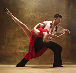 Flexible young modern dance couple posing in studio. - obrazy, fototapety, plakaty