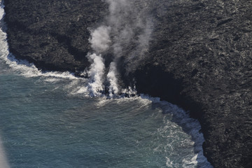 Fototapeta na wymiar Helicopter aerial view of lava entering the ocean and steam, Big Island, Hawaii.