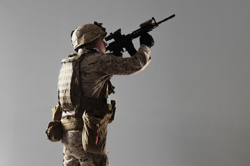 Fototapeta na wymiar Soldier in camouflage holding rifle