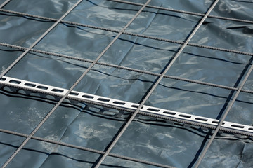Close up of concrete reinforcement steel mesh with linear metal rebar spacer on a construction site