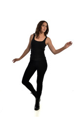 Obraz premium full length portrait of brunette girl wearing black singlet, jeans jeans and boots. standing pose, isolated on white studio background.
