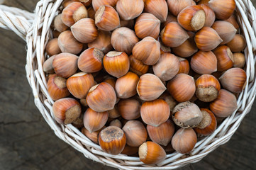 A wicker basket with hazelnut, full of delicious nut, close-up top view